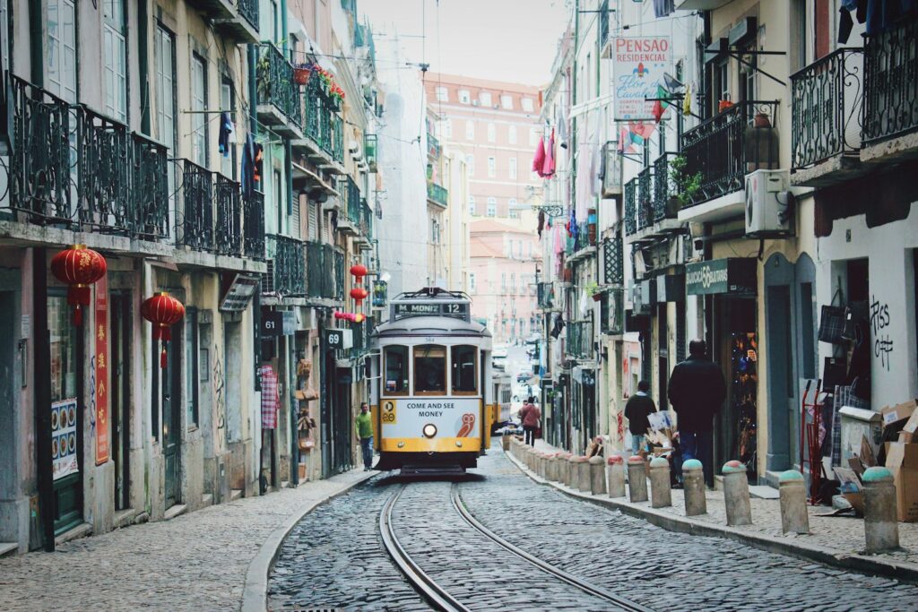 train passing in between buildings portugal lissabon