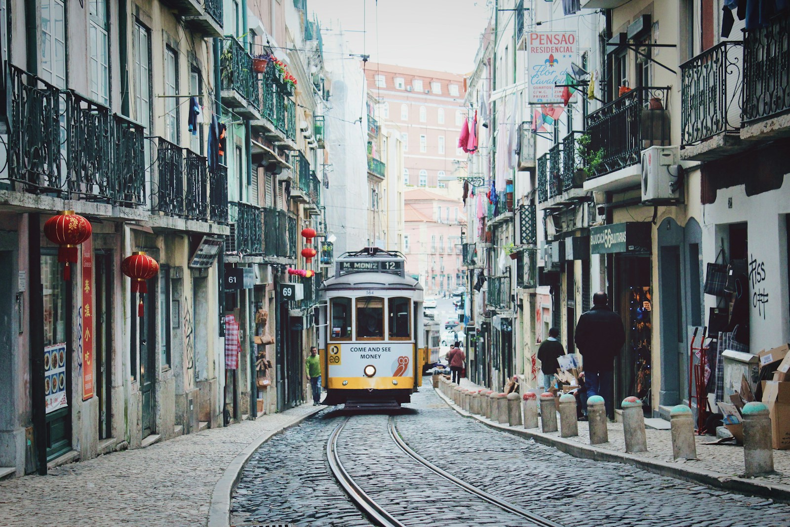 train passing in between buildings portugal lissabon